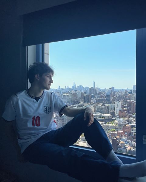 Close crop of Matt on the window ledge, looking out at the skyline
